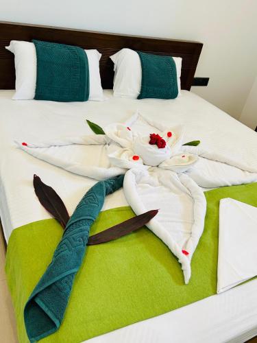 a bed with white towels and flowers on it at Jaffna City Palace Hotel in Jaffna