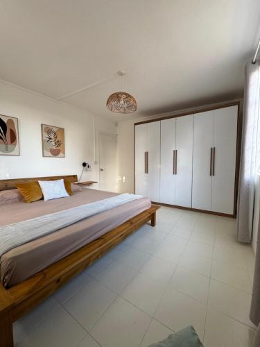 a bedroom with a large bed and white cabinets at Le Nid du Dodo in Albion