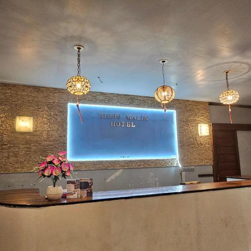a sign on the wall of a hotel at Ridho Malik Hotel in Bumbang