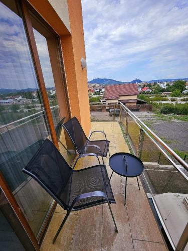 a balcony with two chairs and a table on a building at Pensiune Simona in Deva
