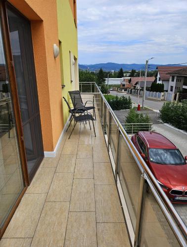 a balcony with a red car and a red car at Pensiune Simona in Deva