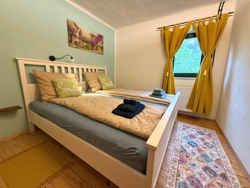 a bedroom with a bed with yellow curtains and a window at Apartment - direkt am Fluss, balkon, rustikal, idylisch in Grünau im Almtal