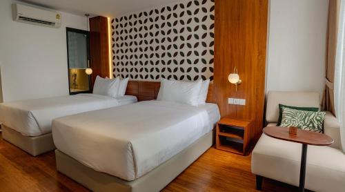 a hotel room with two beds and a couch at The Scenic Hotel in Phnom Penh