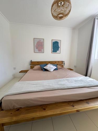 a bedroom with a large bed with a wooden frame at Le Nid du Dodo in Albion