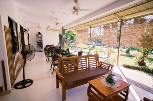 a restaurant with tables and chairs and a large window at Selectum Mangrove Resort in Panglao
