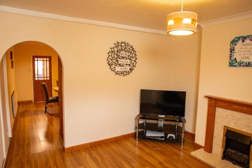 a living room with a tv and a fireplace at Mansfield House - Sleeps 10, Free Parking, WiFi - Weekly & Monthly Stay Deals! in Mansfield