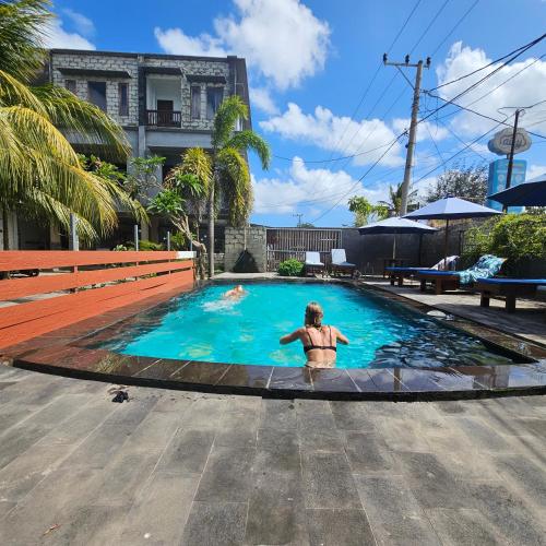 a person is standing in a swimming pool at Ridho Malik Hotel in Bumbang