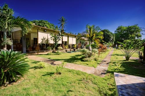 a house with a garden with palm trees at Selectum Mangrove Resort in Panglao