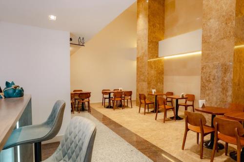 a restaurant with tables and chairs in a room at The Scenic Hotel in Phnom Penh