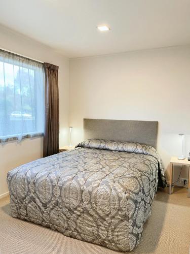 a bedroom with a large bed and a window at Anchorage Motel Apartments in Te Anau