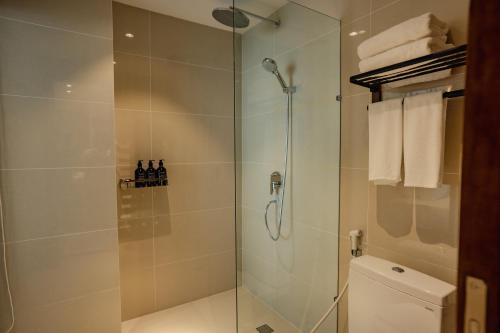 a bathroom with a glass shower with a toilet at The Scenic Hotel in Phnom Penh