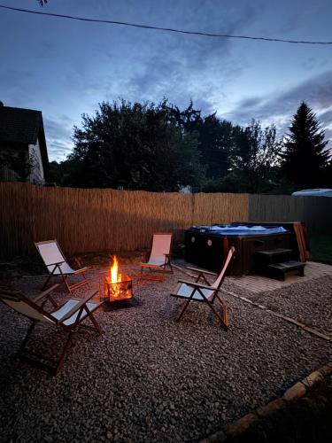 a group of chairs and a fire in a backyard at Tavelina Vendégház in Abaliget