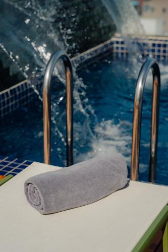 a towel sitting on a table in front of a swimming pool at The Scenic Hotel in Phnom Penh
