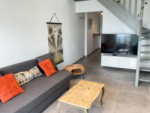 Una sala de estar con un sofá y un televisor. en La Prom 2 - a two bedroom apartment with a sea view, en Niza