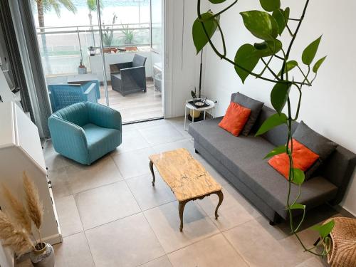 a living room with a couch and a chair and a table at La Prom 2 - a two bedroom apartment with a sea view in Nice