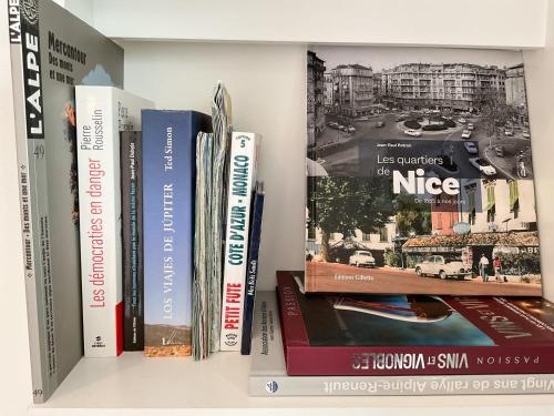 a shelf with books and magazines on it at La Prom 2 - a two bedroom apartment with a sea view in Nice