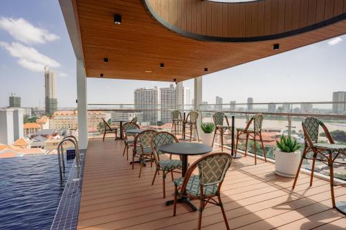 a balcony with tables and chairs on a roof at The Scenic Hotel in Phnom Penh