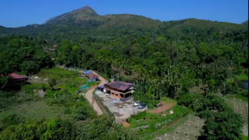 an aerial view of a house in the middle of a forest at Alekadu hill view homestay in Mudigere