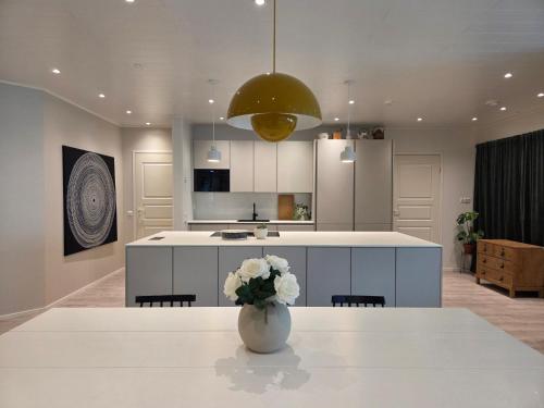 a kitchen with a vase with flowers on a table at Spacious home near Santa Claus Village in Rovaniemi