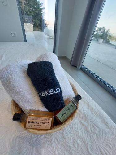 ニドリにあるVilla Ninemiaのベッドの上にタオルとエンナウィンドのボトル