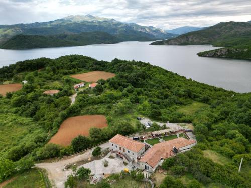 an aerial view of a house on a hill next to a lake at Bujtina Rragam in Rragam