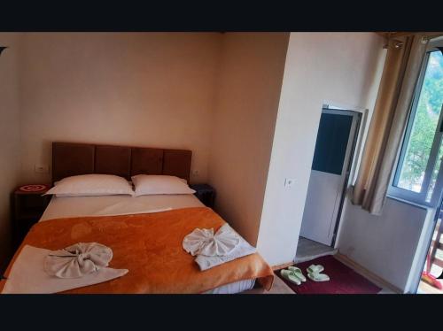 a bedroom with a bed with two towels on it at Mikel Center Theth Guesthouse in Shkodër