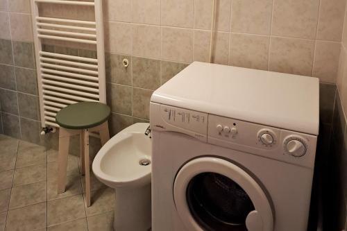 a washing machine in a bathroom next to a toilet at Casa Editta in Bobbio Pellice