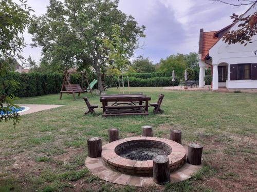 a fire pit in a yard with a picnic table at Hétkanyar Vendégház in Nagyvázsony
