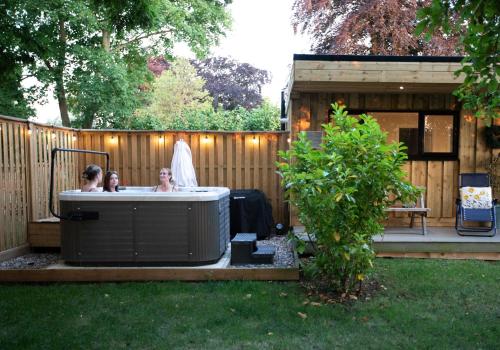 a group of people in a hot tub in a backyard at Luxury Chestnut Lodge with Hot Tub and Games Room in Toppesfield