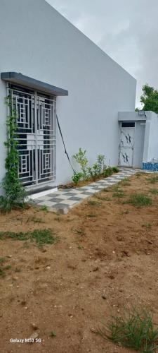 a white building with a door on the side of it at Om Villa in Mandvi