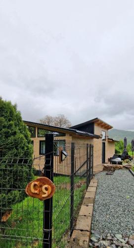 a fence with a sign on it in front of a house at Casa nouă in Vişeu de Sus