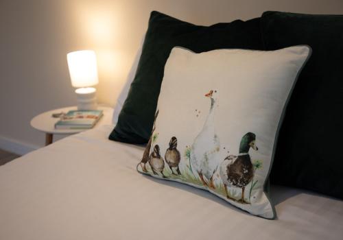 a pillow with a group of ducks on a bed at Luxury Chestnut Lodge with Hot Tub and Games Room in Toppesfield