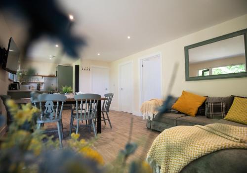 a living room with a couch and a table and chairs at Luxury Chestnut Lodge with Hot Tub and Games Room in Toppesfield