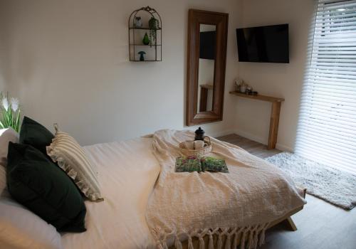 a bedroom with a white bed and a mirror at Luxury Chestnut Lodge with Hot Tub and Games Room in Toppesfield