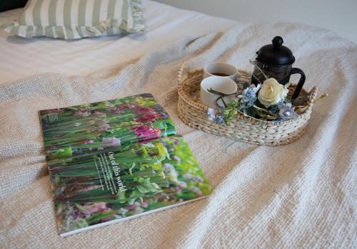 a bed with a table with a tray of flowers and candles at Luxury Chestnut Lodge with Hot Tub and Games Room in Toppesfield