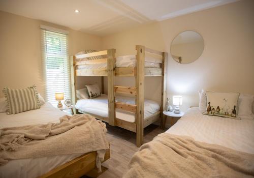 a bedroom with two bunk beds and a mirror at Luxury Chestnut Lodge with Hot Tub and Games Room in Toppesfield