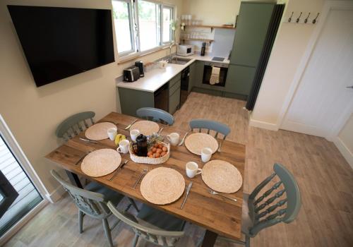 a wooden table with a bowl of food on it at Luxury Chestnut Lodge with Hot Tub and Games Room in Toppesfield