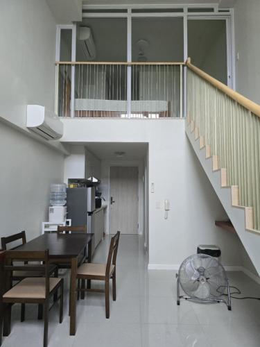 a kitchen and dining room with a table and a staircase at Mandani Bay Suites Tower 2 - Cebu City in Mandaue City