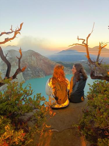 two women sitting on top of a mountain overlooking a lake at Nio Homestay and Tour in Licin