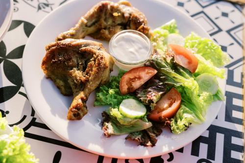 a plate of food with chicken and salad on a table at Selectum Mangrove Resort in Panglao