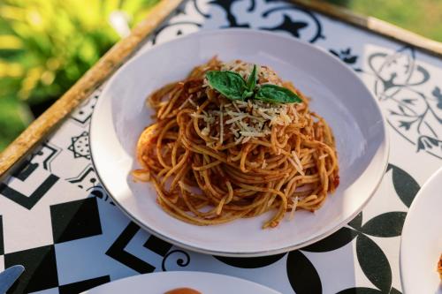 a bowl of spaghetti with a green leaf on a table at Selectum Mangrove Resort in Panglao