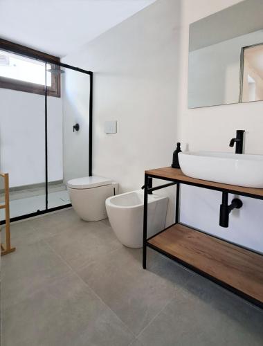 a bathroom with two sinks and a tub and a toilet at B&B L'alba Nel Golfo in Castelsardo