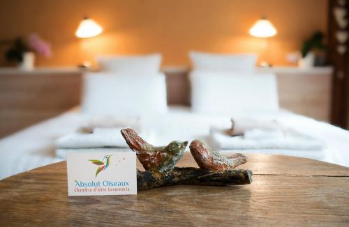 une table avec deux biscuits sur un lit dans l'établissement Absolut Oiseaux, à Parisot