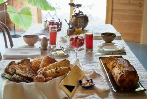 une table avec du pain, des viennoiseries et des verres de vin dans l'établissement Absolut Oiseaux, à Parisot