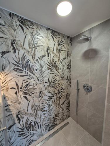 a bathroom with a shower with a mural of plants at 3 Amici all'Arena in Verona