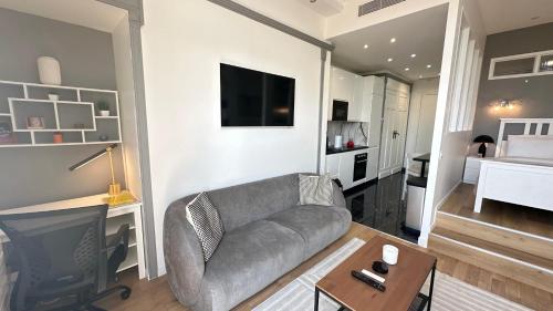a living room with a couch and a television at Suite luxueuse Avenue des Champs-Élysées in Paris