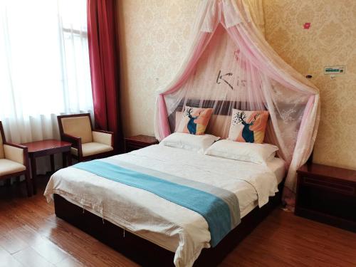 a bedroom with a large bed with a canopy at Emeishan Moon Bay Hotel in Emeishan