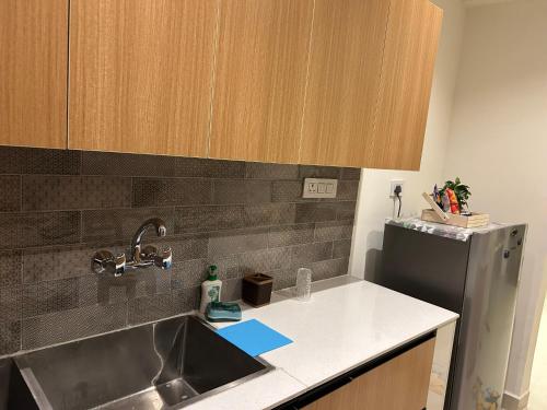 a kitchen with a sink and a refrigerator at Nivaasa Luxe in Kharar