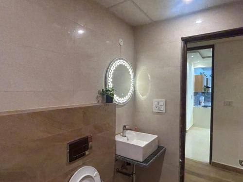 a bathroom with a sink and a mirror and a toilet at Nivaasa Luxe in Kharar