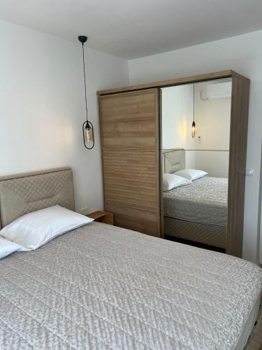 a bedroom with two beds and a large mirror at Mali Raj in Ljubuški